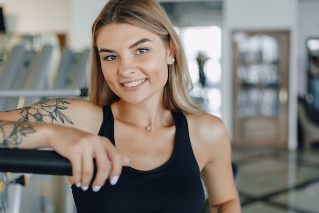 Attractive athletic girl standing near gym equipment. healthy lifestyle.