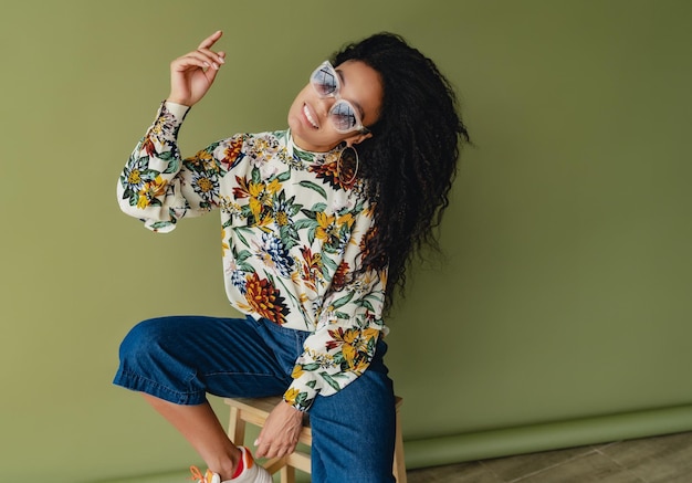 Attractive black african american woman in stylish outfit on green studio background