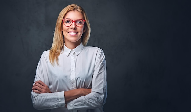 Free photo attractive blond business woman in a white shirt, eyeglasses and crossed arms over grey background.