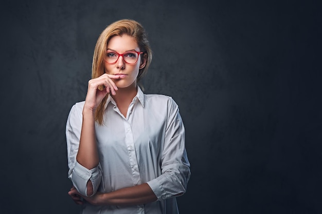 Attractive blond business woman in a white shirt over grey background.