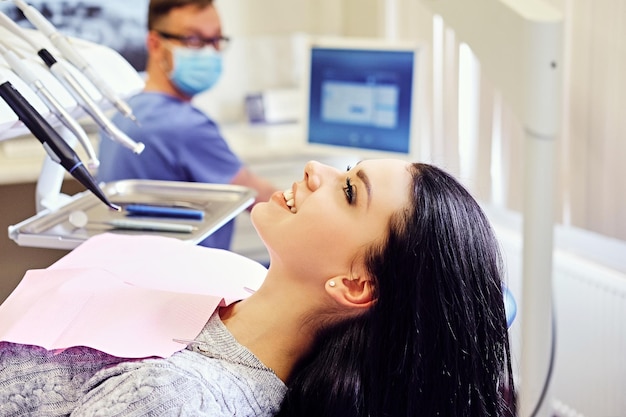 Free photo attractive brunette female on a dentist chair in a stomatology room.