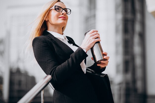 Attractive business woman drinking coffee outside