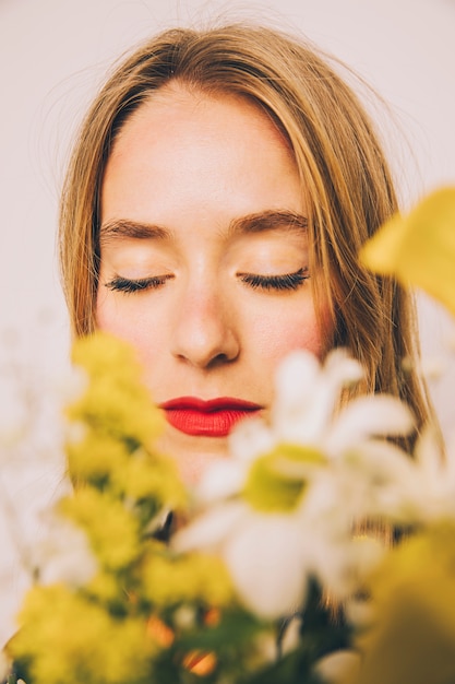 Attractive confident woman standing behind fresh blooms