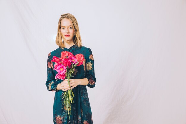 Attractive confident woman with bouquet of blooms