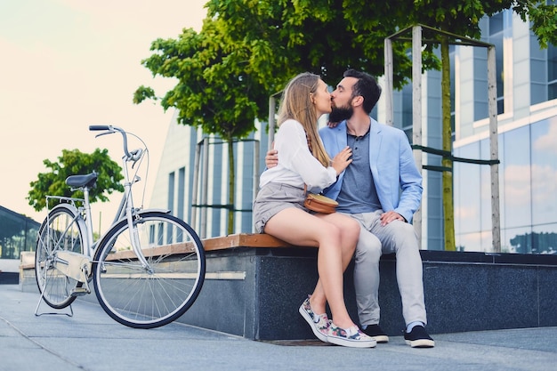 Free photo attractive couple on a date after bicycle ride in a city. a man kissing a woman.