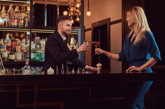 Attractive couple is spending the evening in a romantic setting, drinking wine at the bar counter.