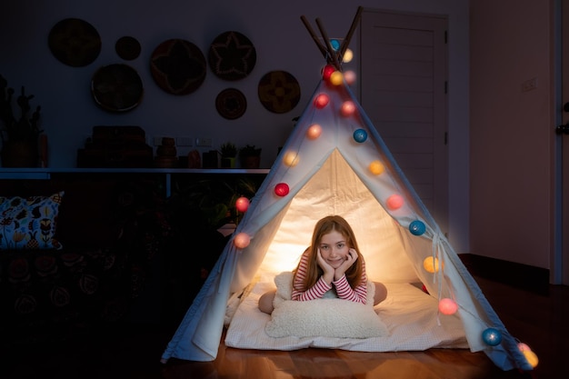 Free Photo attractive cute girl sitting inside tepee tent in her bedroom enjoy happy time