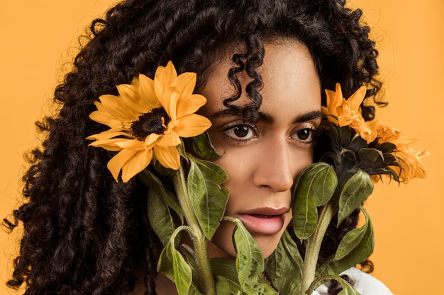 Free photo attractive ethnic thinking woman with flowers