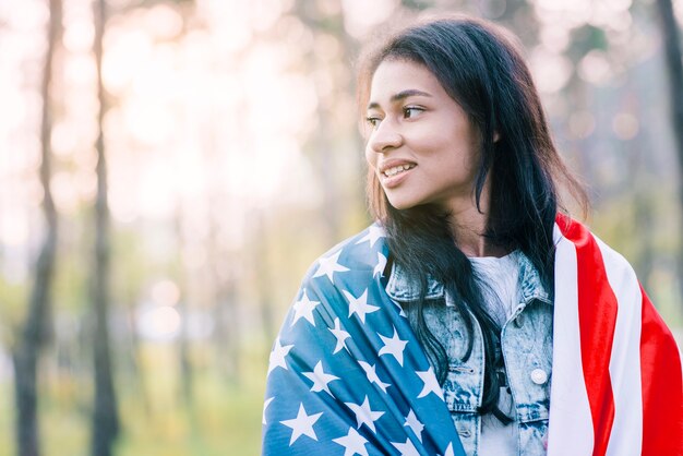 Attractive ethnic woman posing with flag of USA