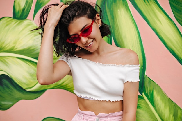 Free photo attractive european woman smiling in front of graffiti