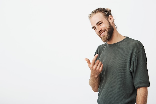 Free photo attractive famous singer beckoning with finger and smiling gently