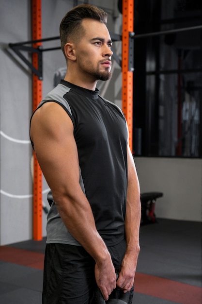 Attractive fit man working out indoors with dumbbells