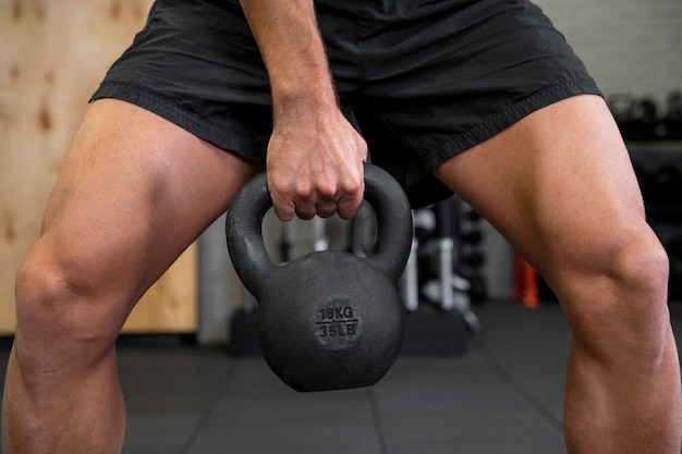 Attractive fit man working out indoors with dumbbells