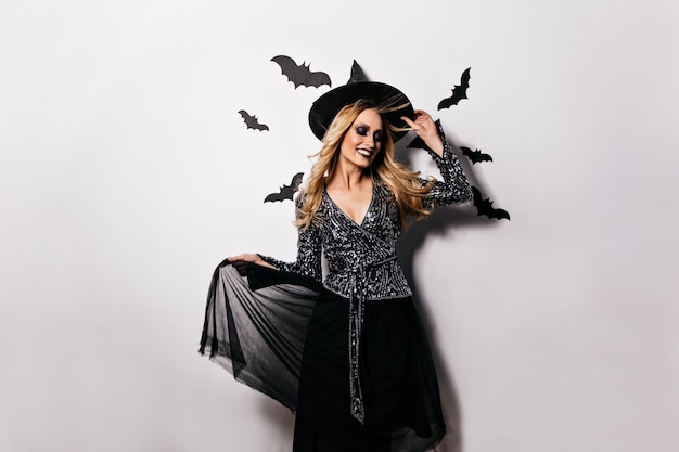 Free photo attractive girl in carnival attire smiling . refined blonde witch celebrating halloween.