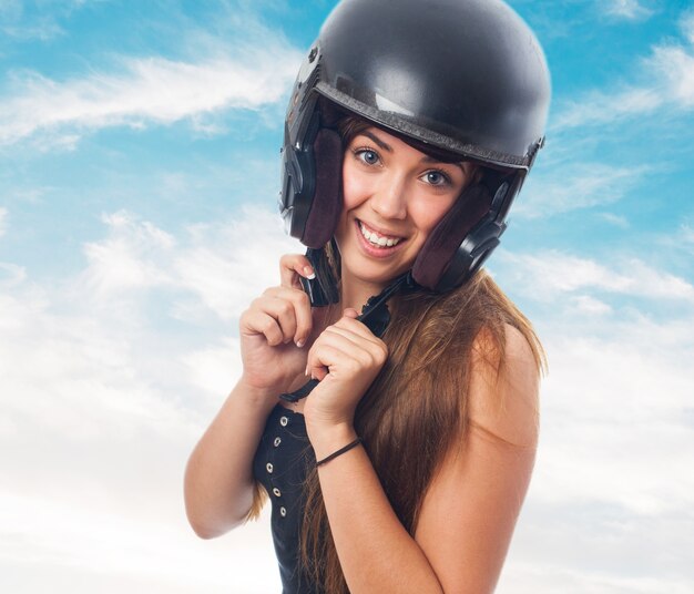 Attractive girl holding helmet on head.