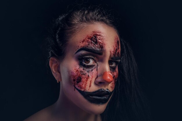 Attractive girl is ready for Halloween, she has very creepy makeup on her face.