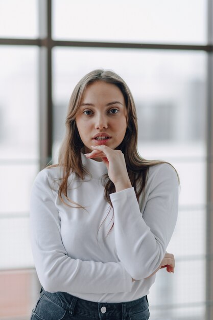 Attractive girl on the window shows different emotions and mood. 