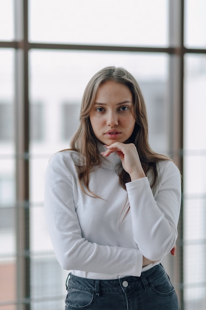 Attractive girl on the window shows different emotions and mood. 