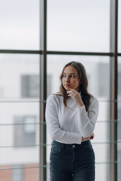 Attractive girl on the window shows different emotions and mood. 