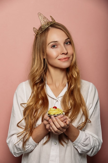 Attractive girl with a crown and cupcake