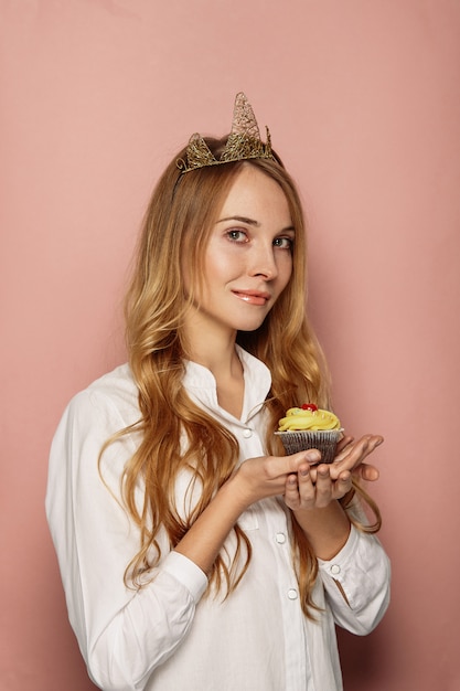 Free photo attractive girl with a crown and cupcake