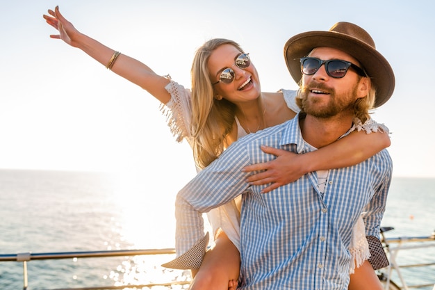 Free photo attractive happy couple laughing traveling in summer by sea, man and woman wearing sunglasses