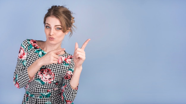 Attractive lady in elegant dress pointing upstairs