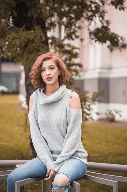 Free photo attractive lady sitting on rail