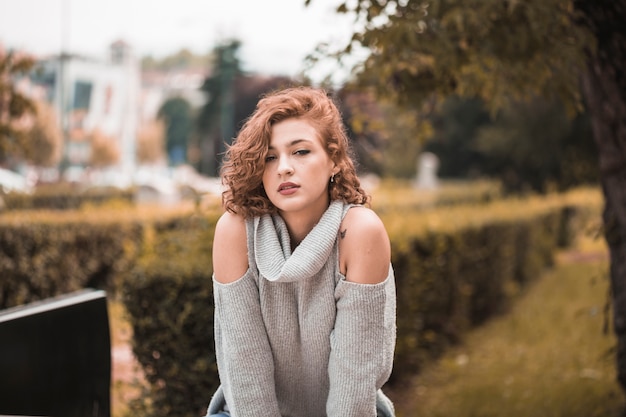 Free photo attractive lady in sweater in public garden