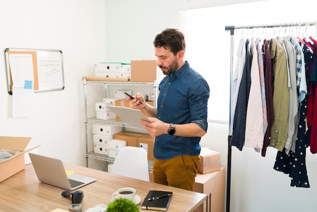 Free photo attractive man in hos 30s texting on the smartphone and sending work e-mails while working at his business office