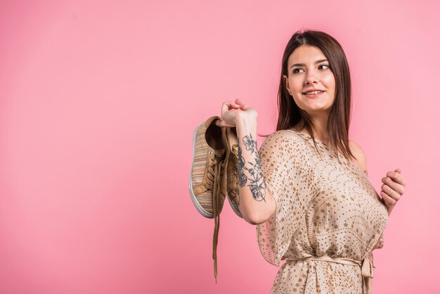 Attractive positive woman holding shoes