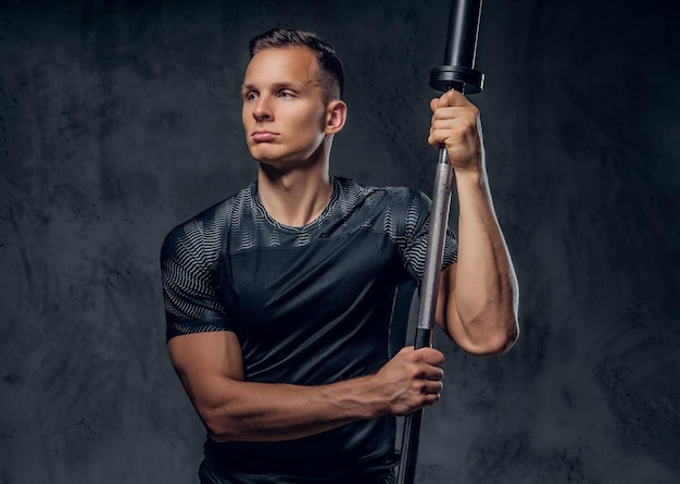 Free Photo attractive power lifter holds barbell over dark grey background.