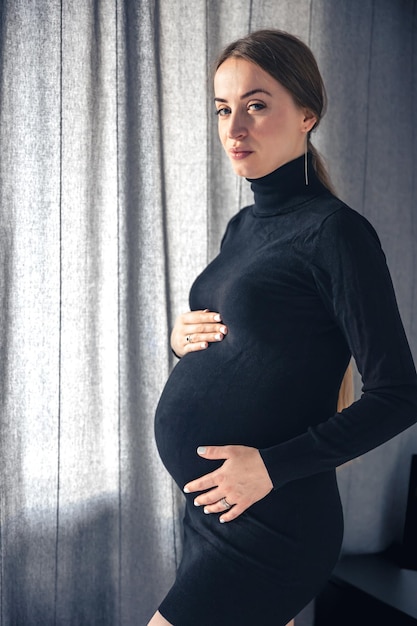 Free Photo attractive pregnant woman in the interior of the room near the window