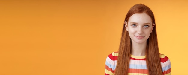 Free photo attractive selfassured redhead girl encouraging herself look mirror confident prepare interview speech standing orange background smirking intrigued listening talking casually