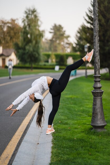 Attractive skinny woman doing a backbend while showing a somersault.