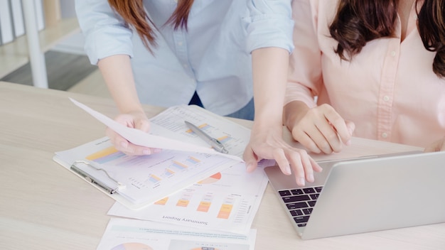 Attractive smart creative Asian business women in smart casual wear working on laptop while sitting 