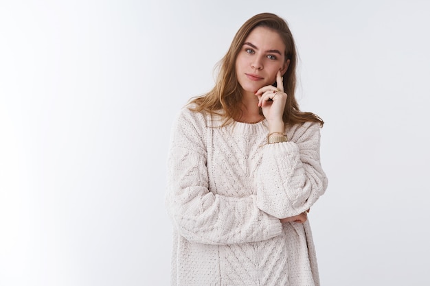 Free photo attractive smart tender young european woman wearing loose cozy warm sweater resting fireplace tilting head touching cheek enjoying comfort smiling happily, relaxed carefree white background