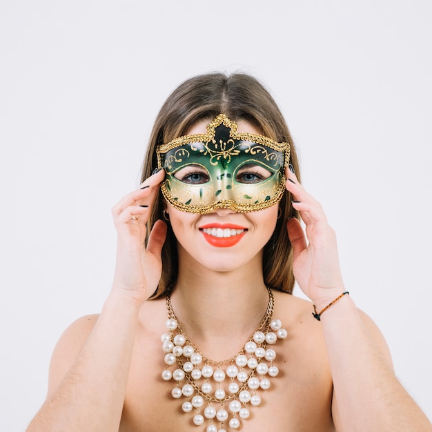 Attractive smiling woman in masquerade carnival mask on white background