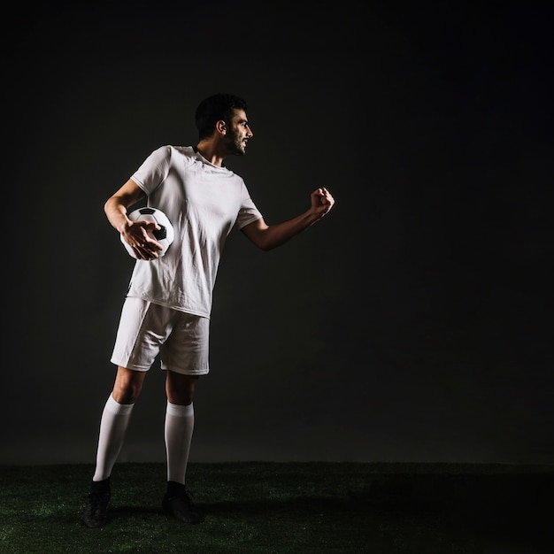 Free photo attractive sportsman with ball celebrating victory