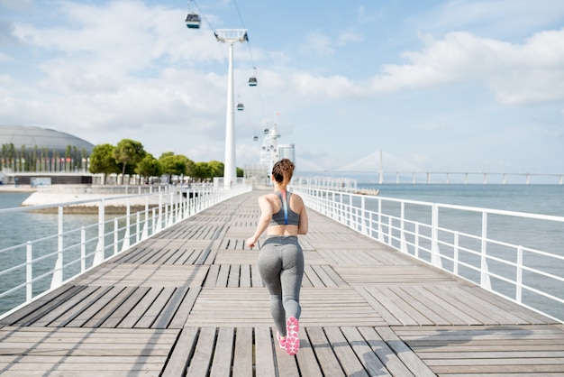 Attractive Sporty Woman Running on Bridge