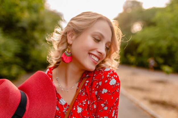 Attractive stylish blond smiling woman in straw red hat and blouse summer fashion outfit