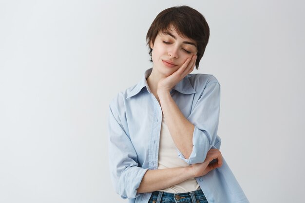 Attractive stylish woman close eyes and leaning on palm to have nap, sleeping