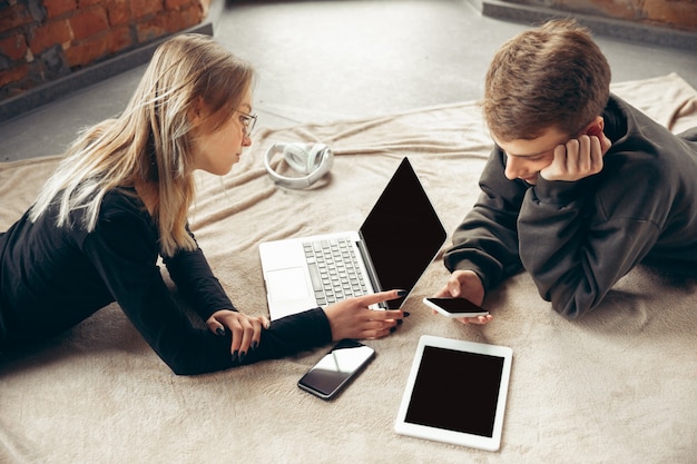 Free photo attractive surprised and amazed couple using devices together