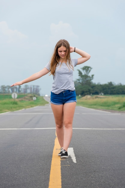 Attractive teenage modern girl dancing on empty street