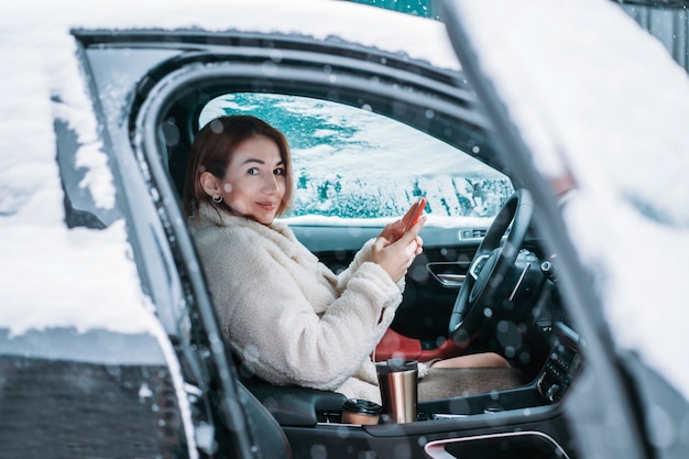 Attractive woman driver nsitting behind the steering wheel in her car