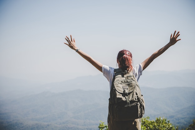 Free photo attractive woman hiker open arms at mountain peak, enjoy with nature. travel concept.