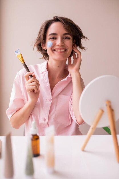 Attractive woman looking and smiling at camera with mask for face