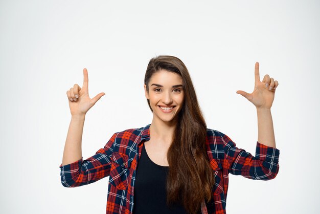 Attractive woman pointing up and smiling