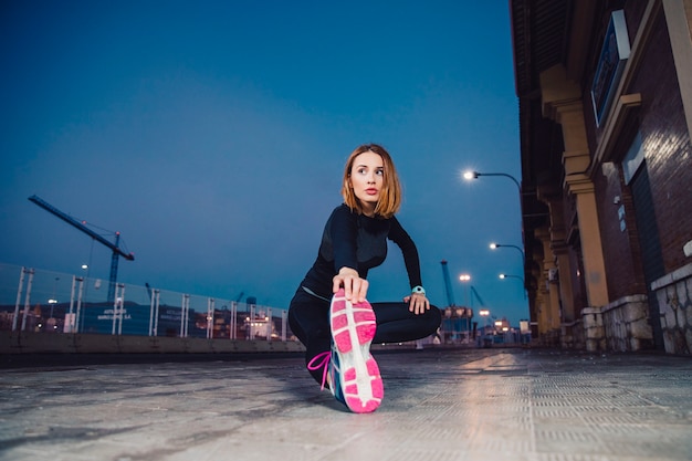 Free photo attractive woman warming up on sidewalk