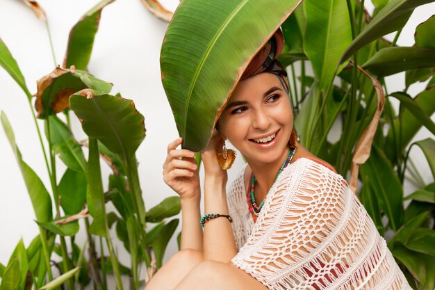 Attractive woman wearing a colorful headscarf like a turban and big round earrings